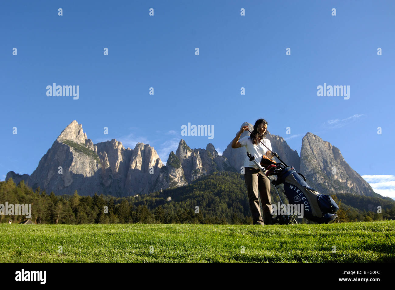 Eine Frau, die ihre Golftasche einen Club herausziehen, Golfplatz Kastelruth-Seiser, Schlern, Südtirol, Italien, Europa Stockfoto