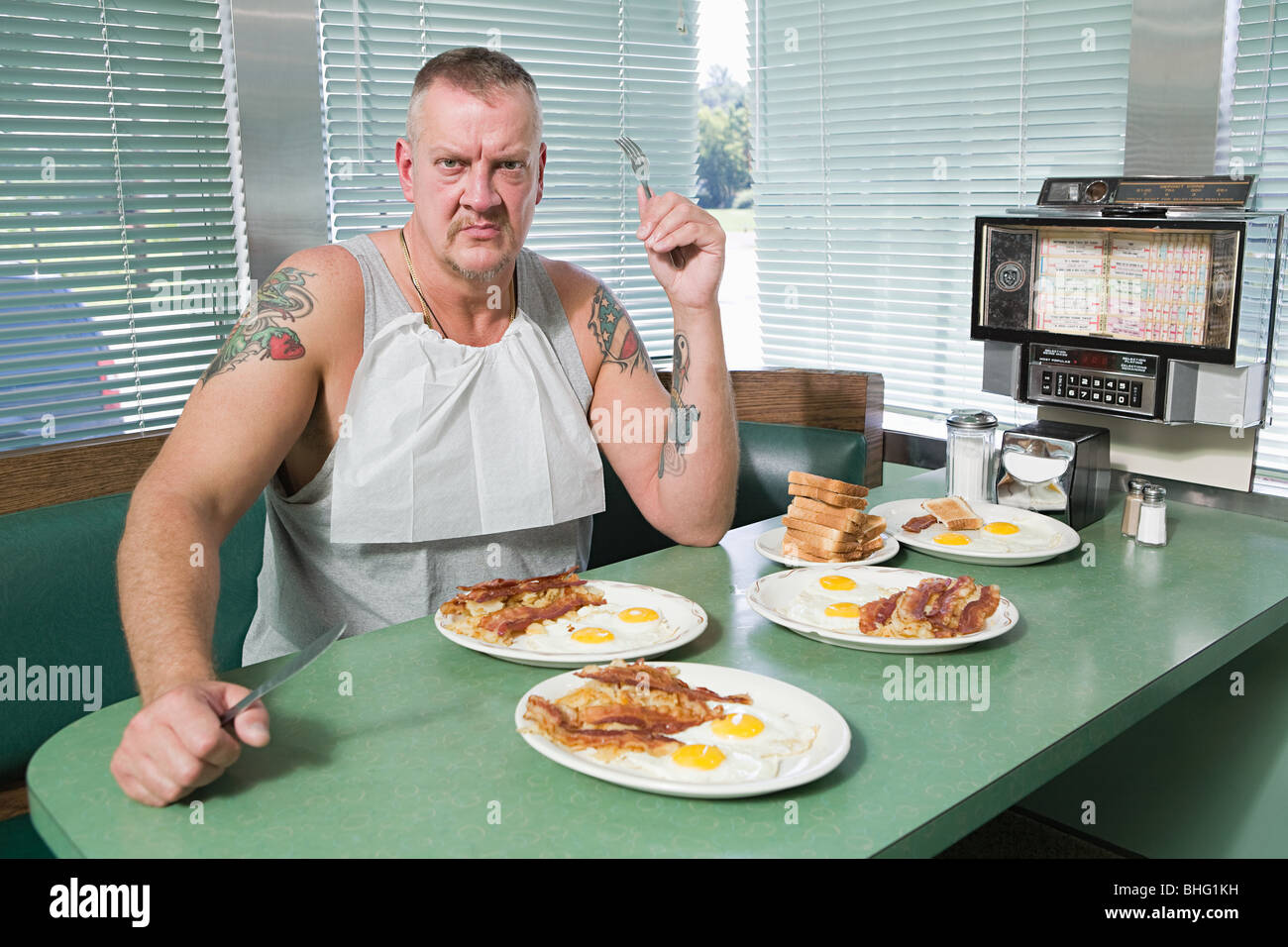 Feindlichen Mann mit Platten von frittierten Lebensmitteln Stockfoto