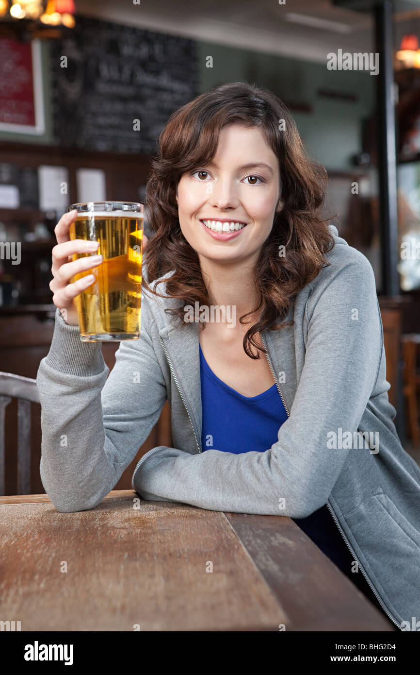 Junge Frau in der Bar mit Bier Stockfoto