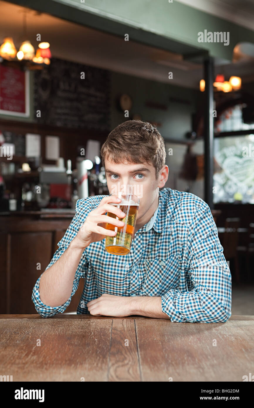 Junger Mann trinkt Bier Stockfoto