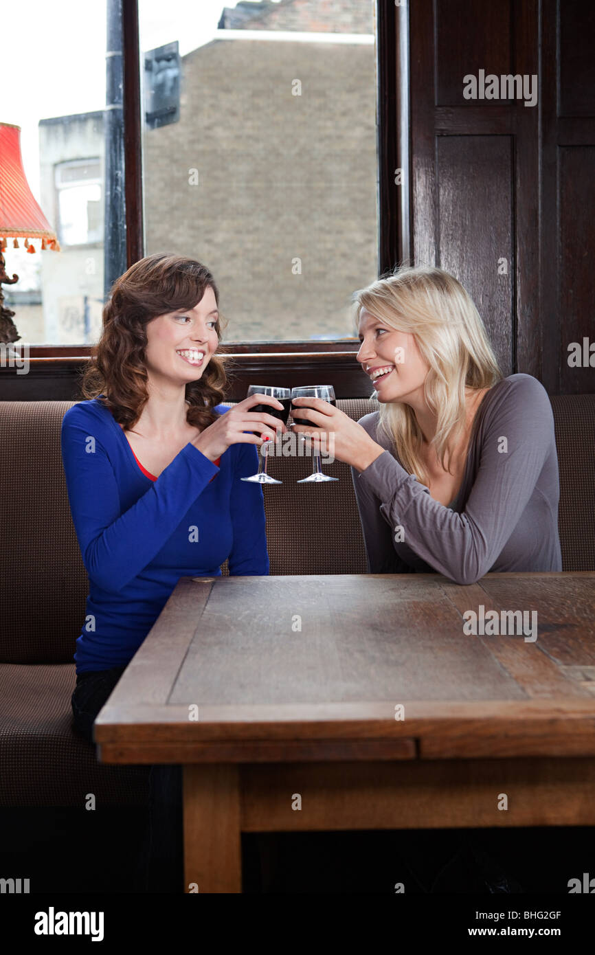 Zwei junge Frauen in bar Toasten mit Wein Stockfoto