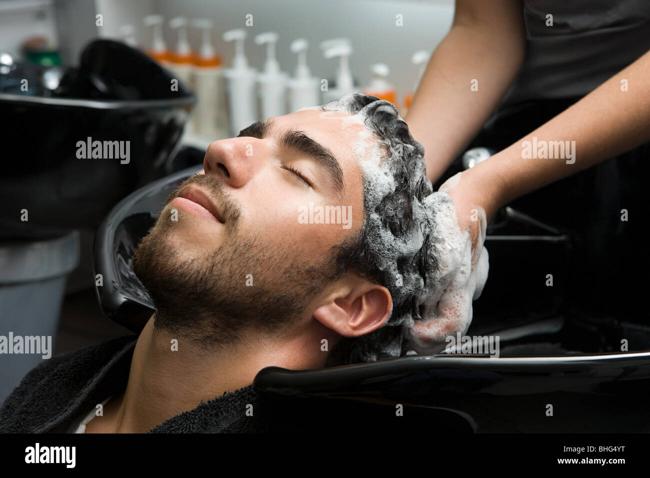 Mann mit seinem Haar shampooniert Stockfoto