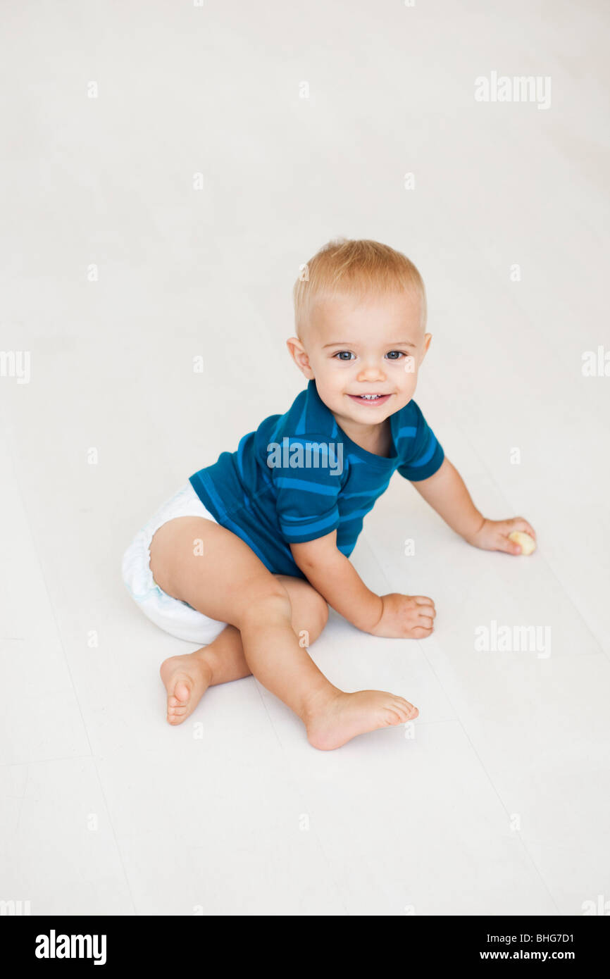 Baby-sitting auf Boden in Windeln Stockfoto