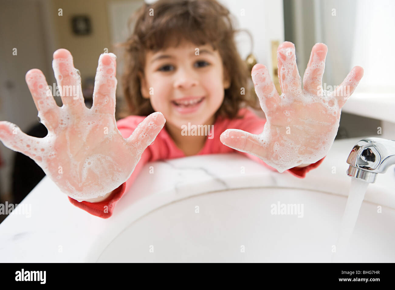 Mädchen mit Seife auf ihren Händen Stockfoto