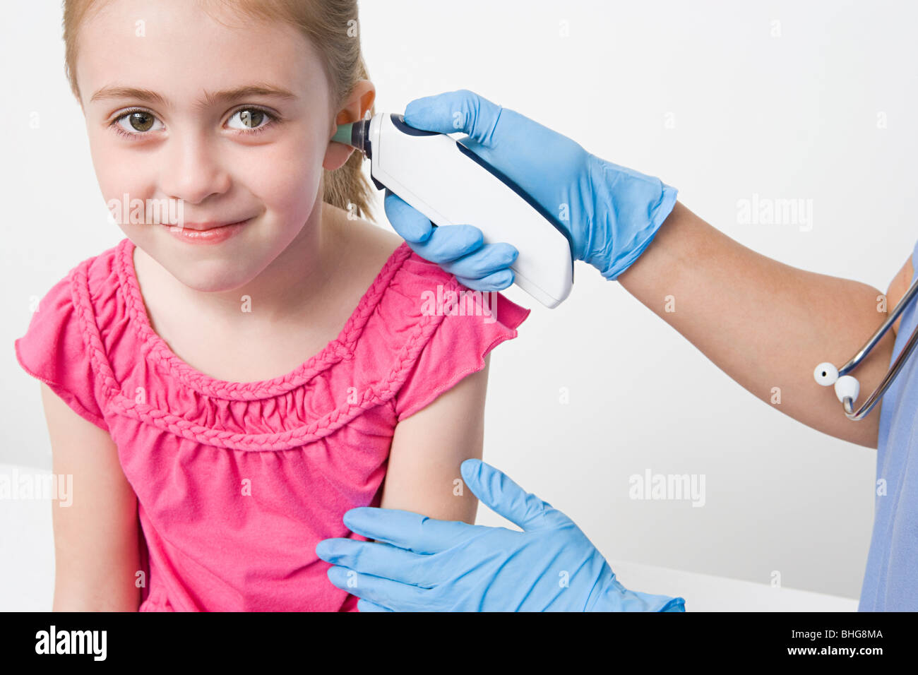 Mädchen mit Thermometer im Ohr Stockfoto