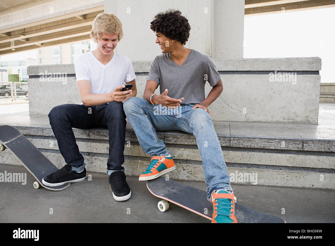 Im Teenageralter mit Skateboards und Handy Stockfoto