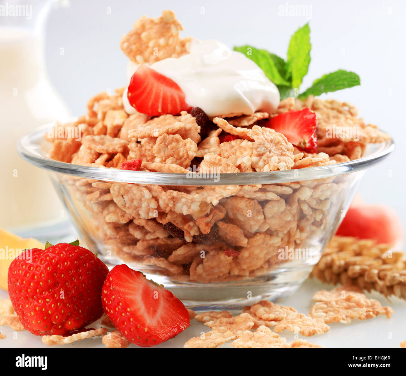 Schüssel mit Frühstücks-Cerealien, garniert mit weißen Joghurt Stockfoto