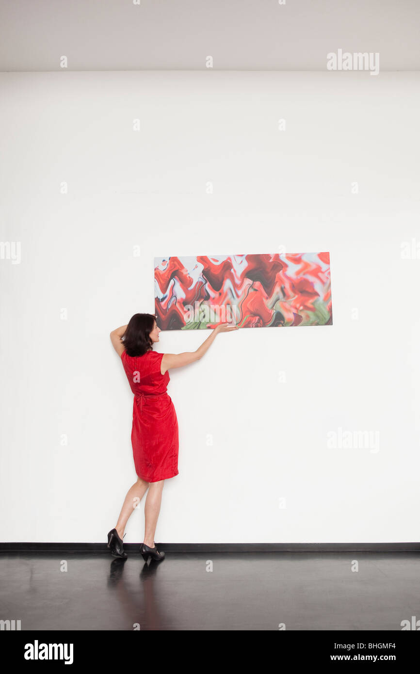 Frau, die ein Bild aufhängen Stockfoto