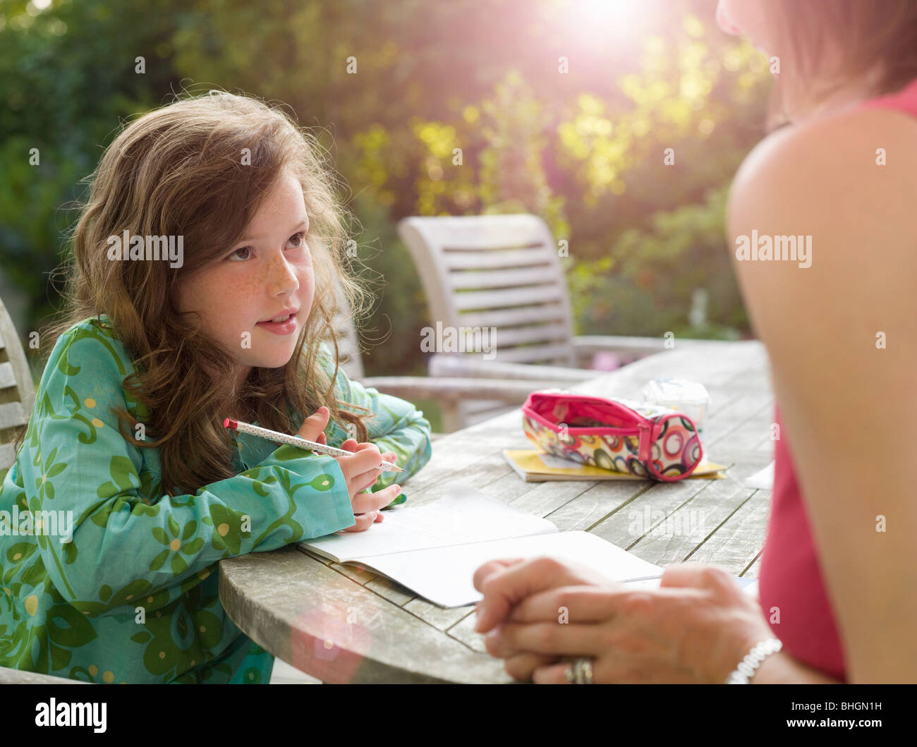 Junge Mädchen und Mutter plaudernd im Garten Stockfoto