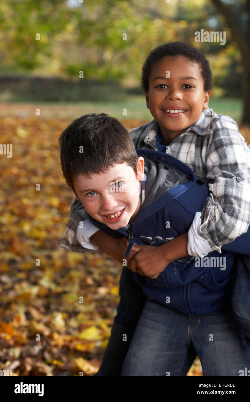 Zwei Jungen spielen im Herbstlaub Stockfoto