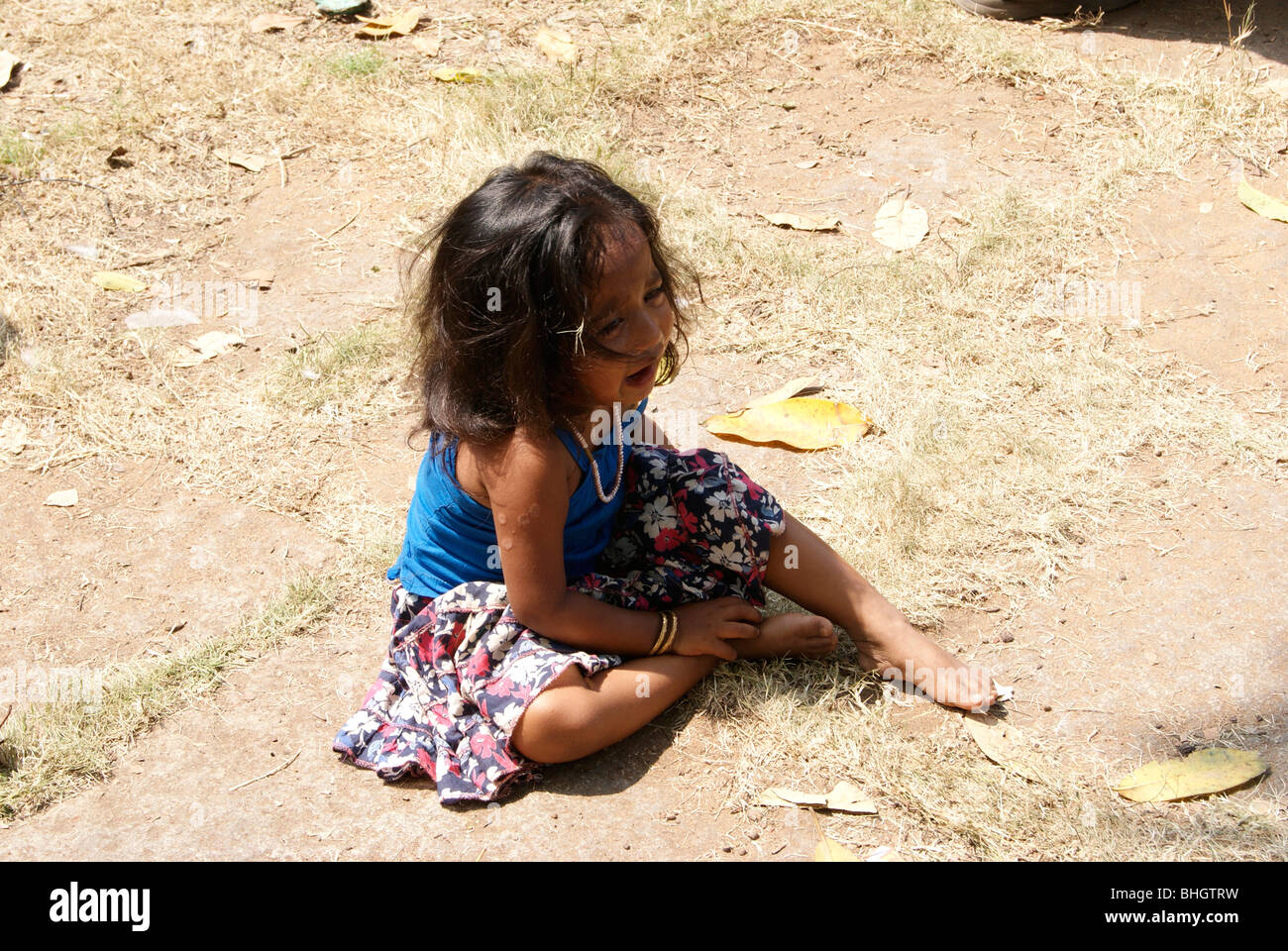 Weinen für Lebensmittel in harten Mittag am Straßenrand. Ein tragisches Bild verletzt und hungrige Kind in Indien. Stockfoto