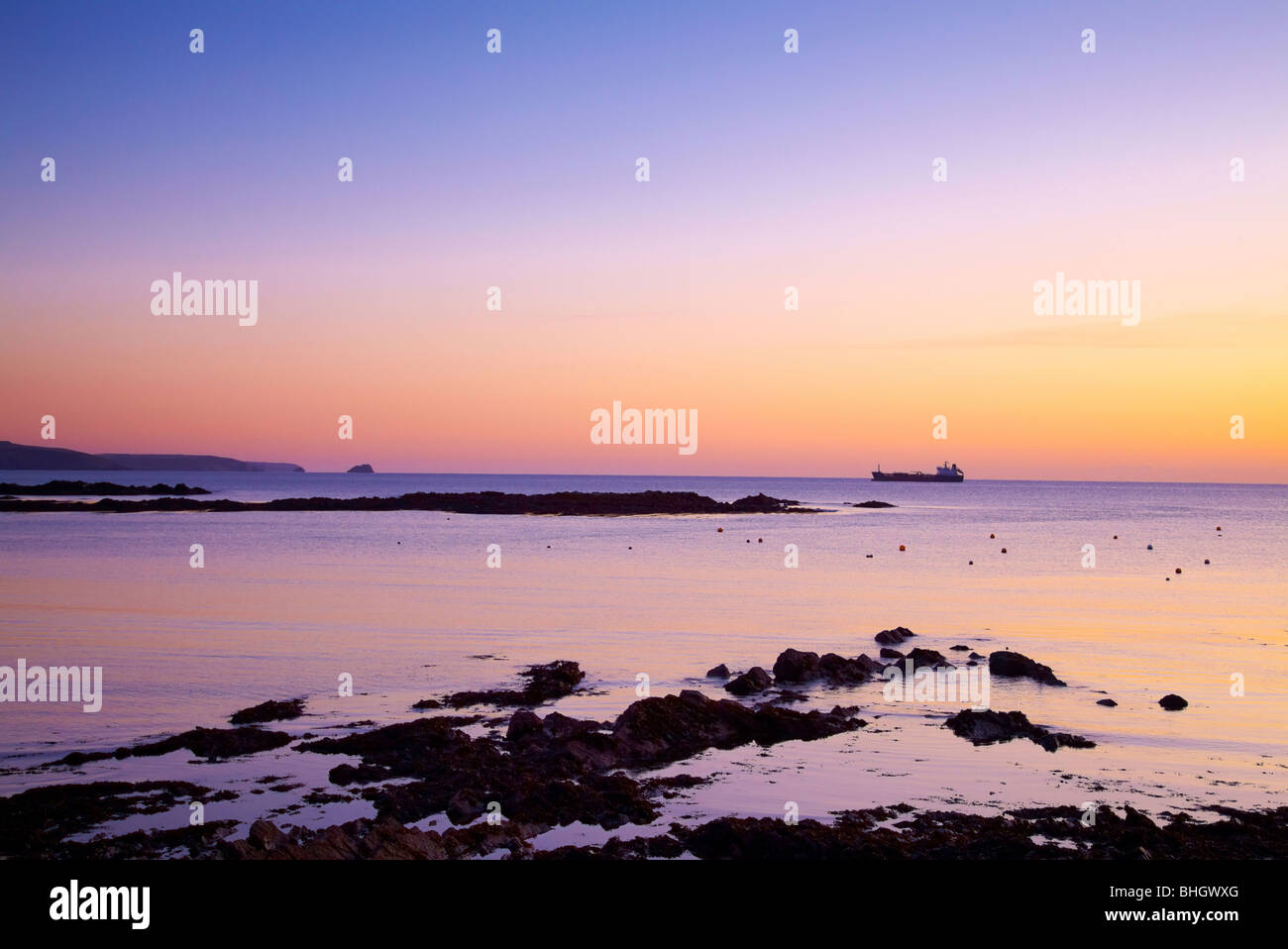 Sonnenaufgang am Cork Harbour, Irland mit Schiff am Horizont Stockfoto