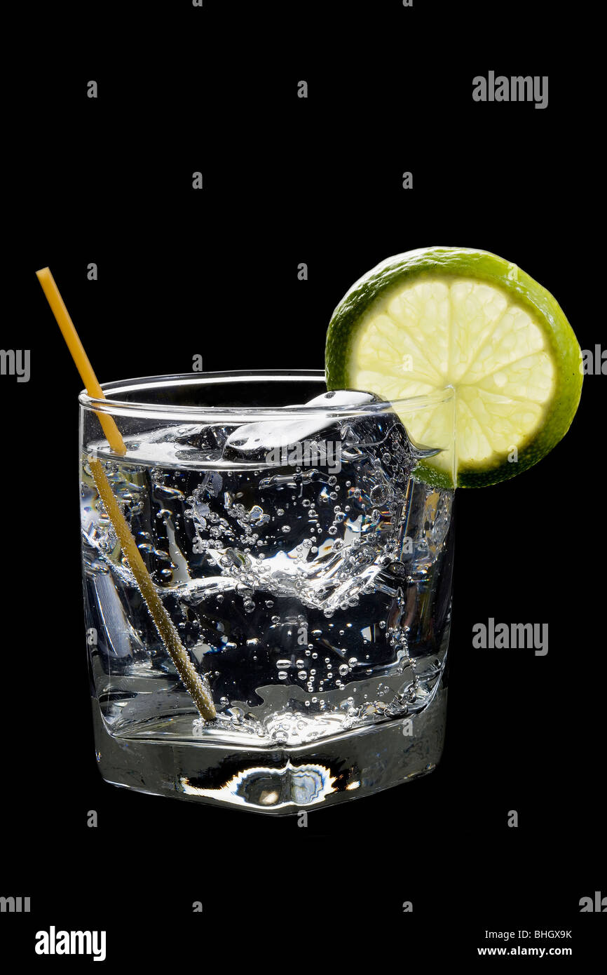 Soda-Club oder Gin oder Wodka und Tonic mit Limettenscheibe garnieren auf schwarzem Hintergrund Stockfoto