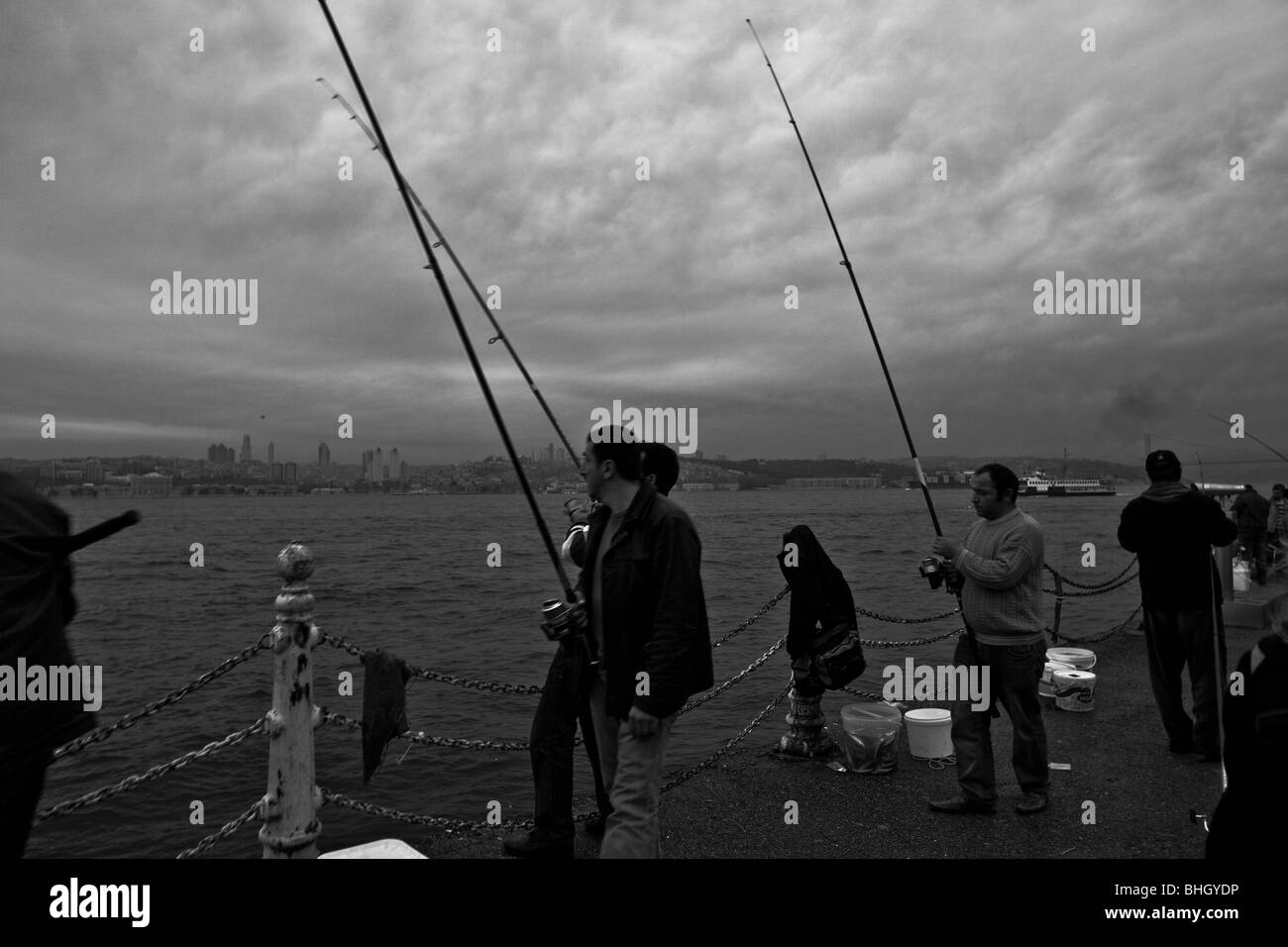 Türkei, Istanbul, Fischer auf den Bosporus, die asiatische Küste bei Sonnenuntergang. Istanbul, Türkei, Europa. Stockfoto