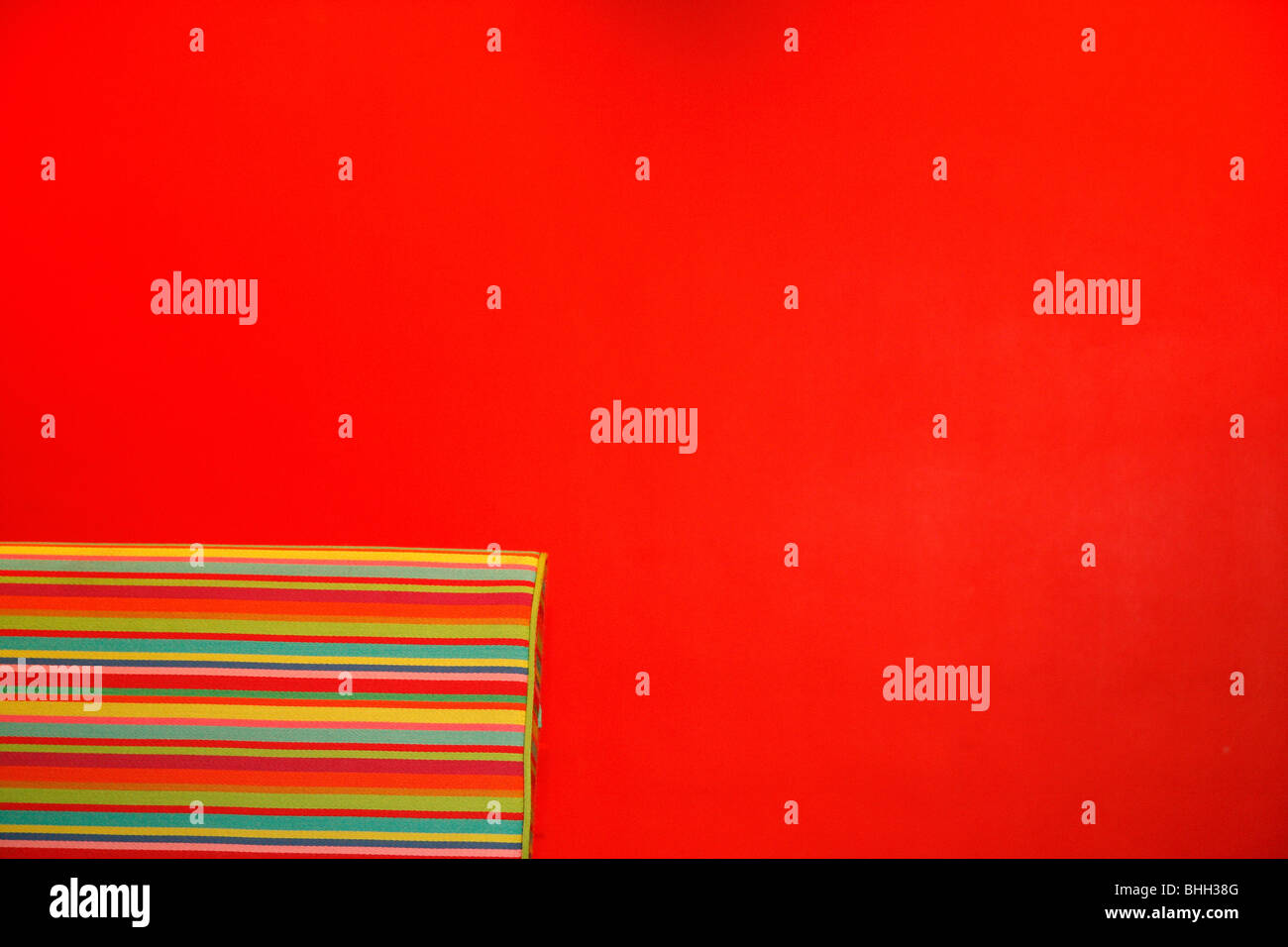Detail Multi farbige gestreifte Couch rote Wand Stockfoto