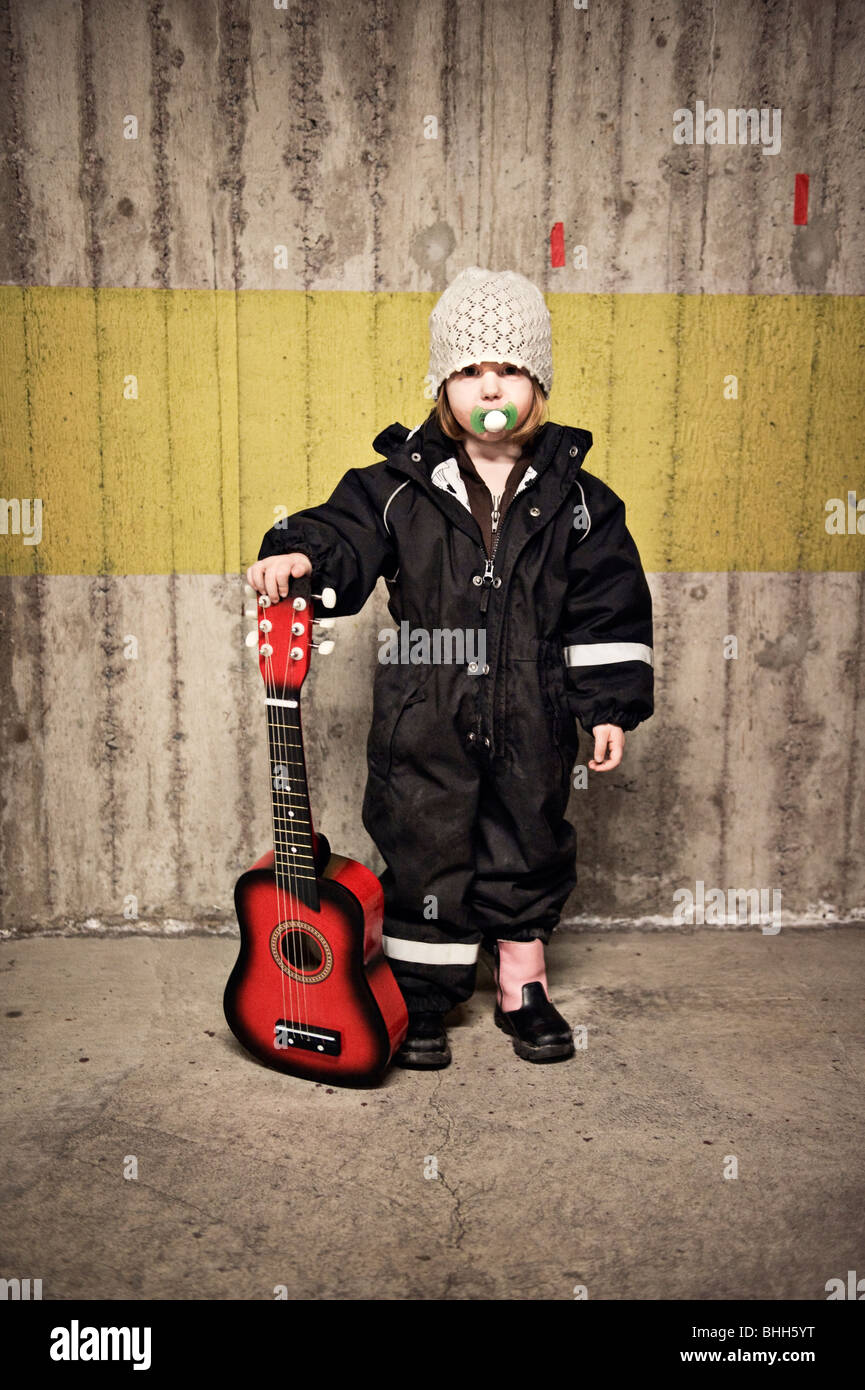 Ein kleines Mädchen mit einer Gitarre, Schweden. Stockfoto