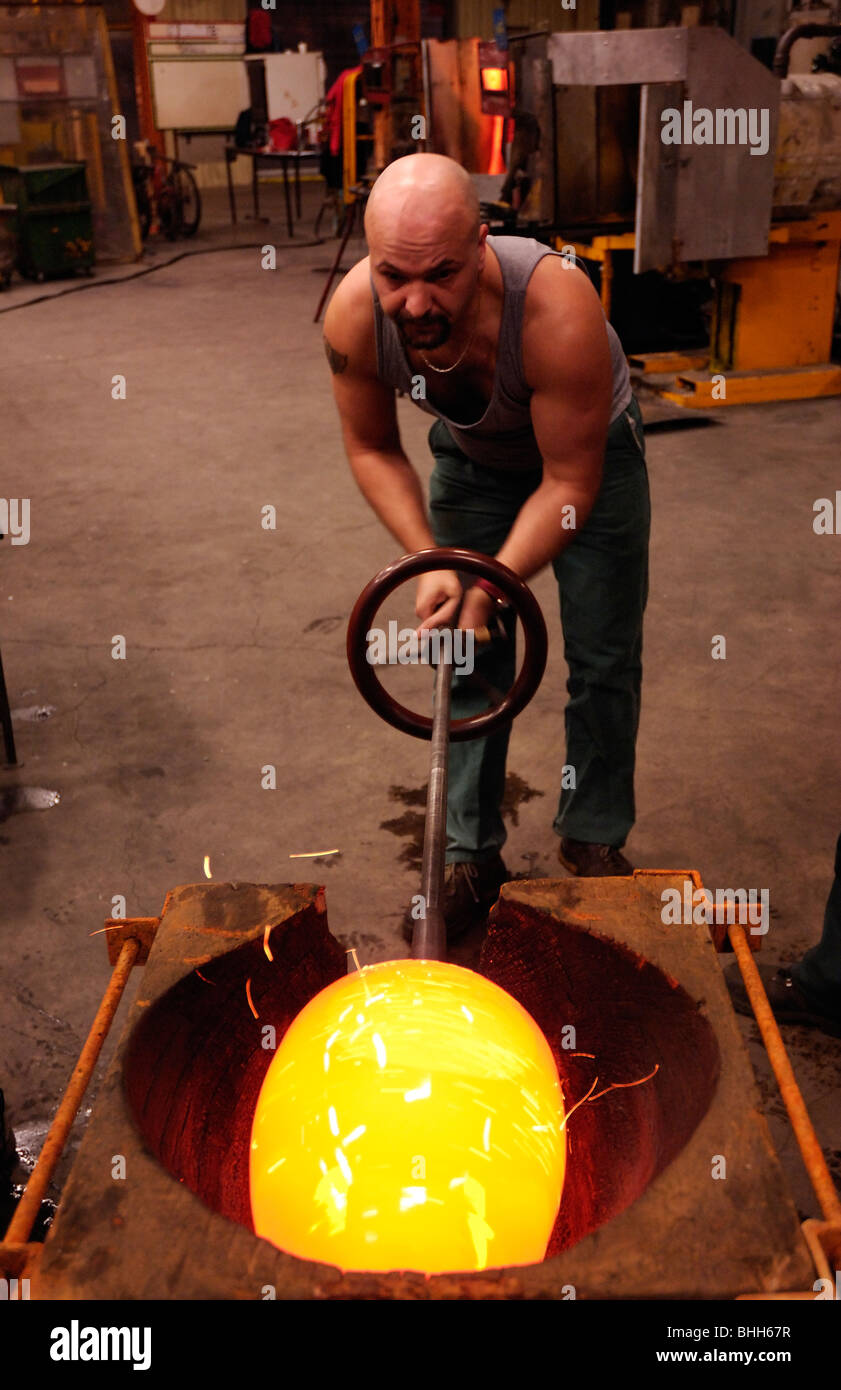 Mann ein 15 kg-Stück aus geschmolzenem Glas in eine Holzform Gestaltung Stockfoto