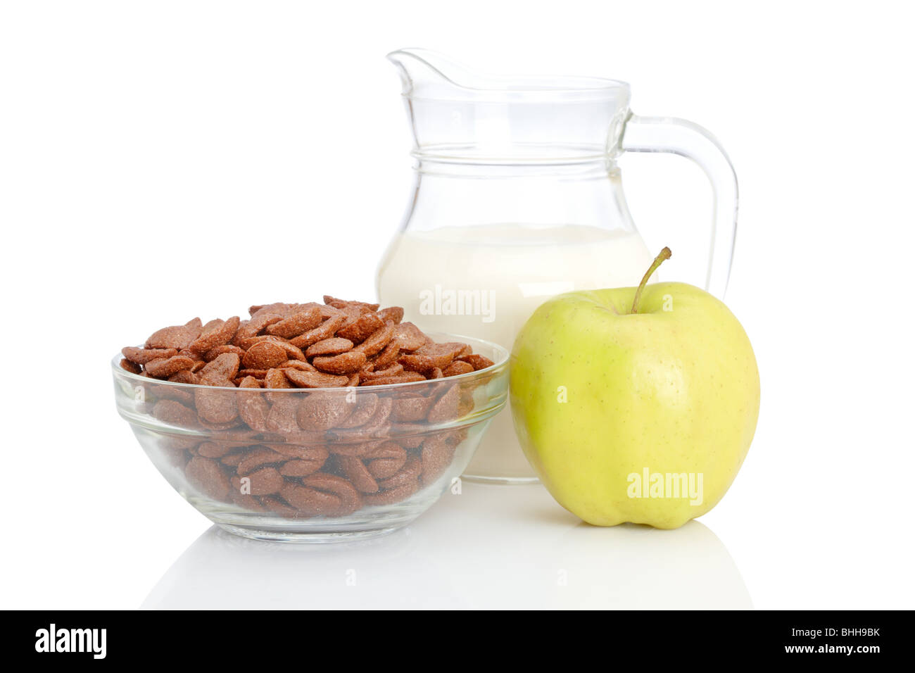 Eine Schale mit frischen Apfel, Schoko Cornflakes und Milch Krug auf weißem Hintergrund... Geringe Schärfentiefe Stockfoto