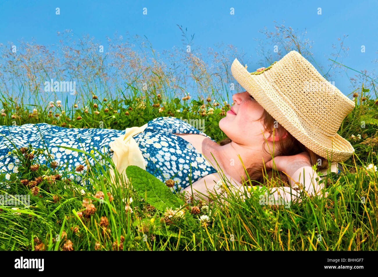 Junge Teenager-Mädchen auf Sommerwiese im Strohhut Stockfoto