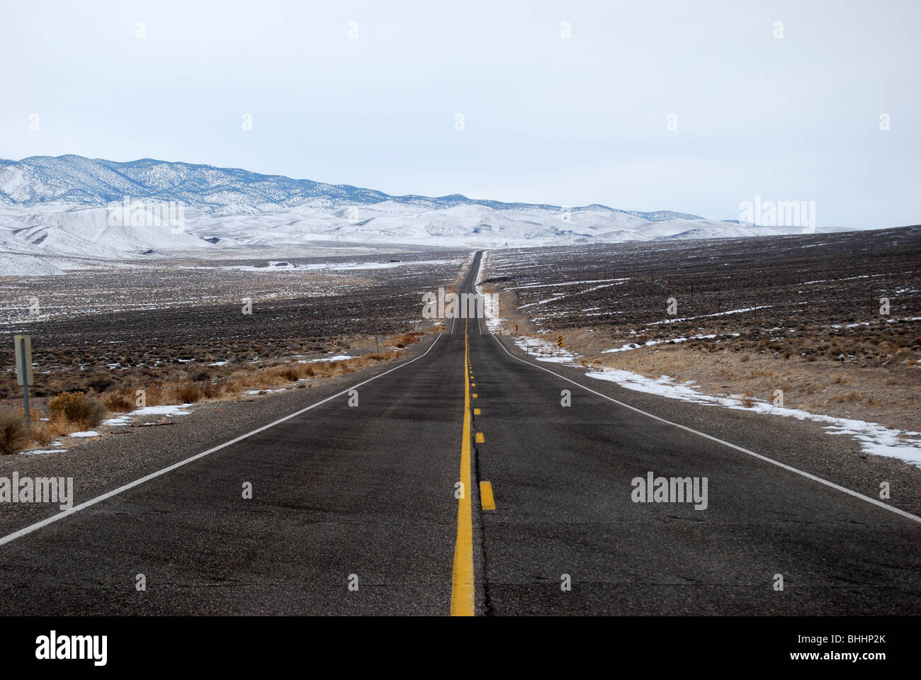lange asphaltierte und steiniger Weg mit Schnee in Landschaft Stockfoto
