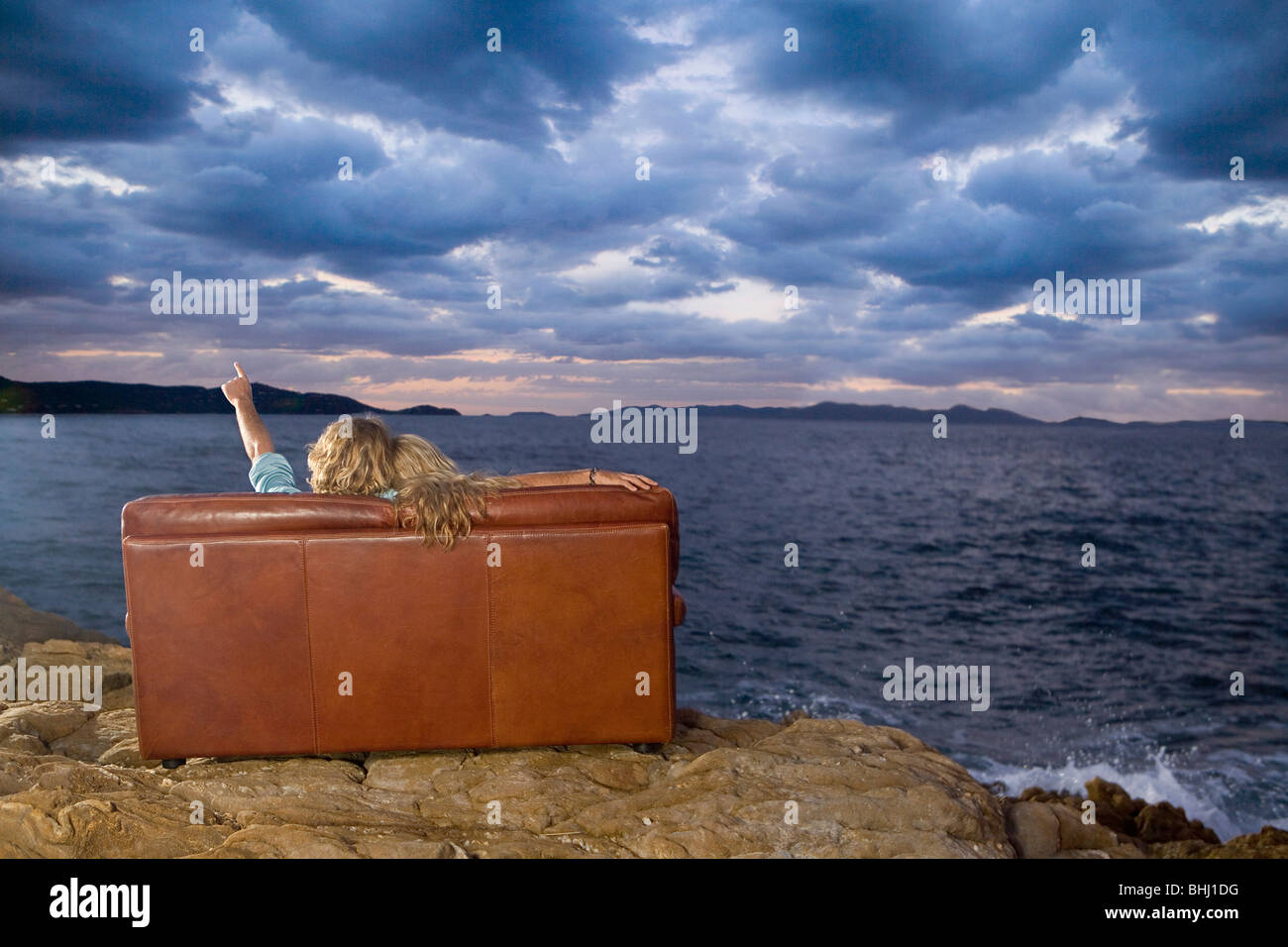 paar auf Couch Blick auf Meer Himmel Stockfoto