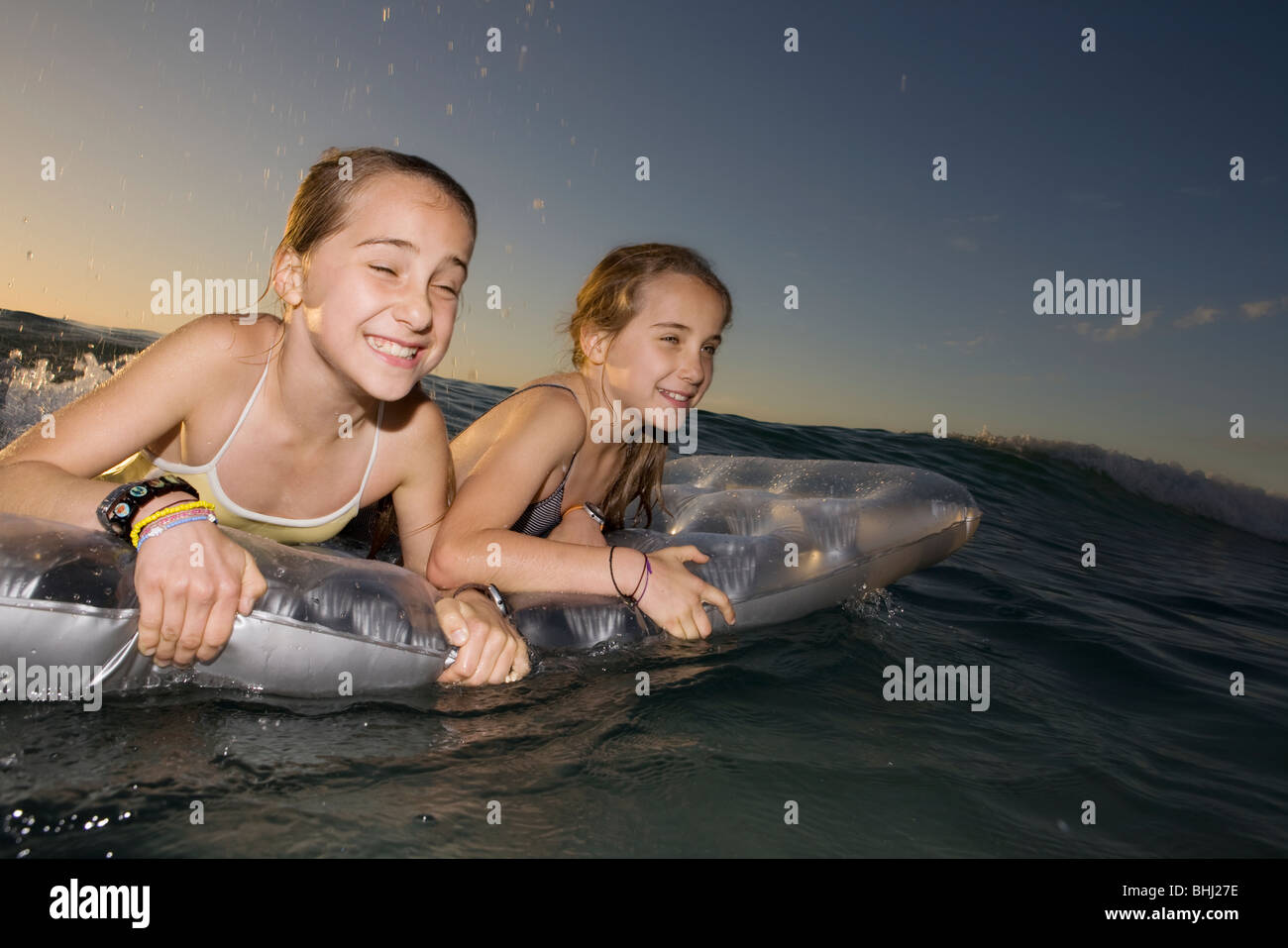Zwei Schwestern Welle surfen auf Luftmatratze Stockfoto