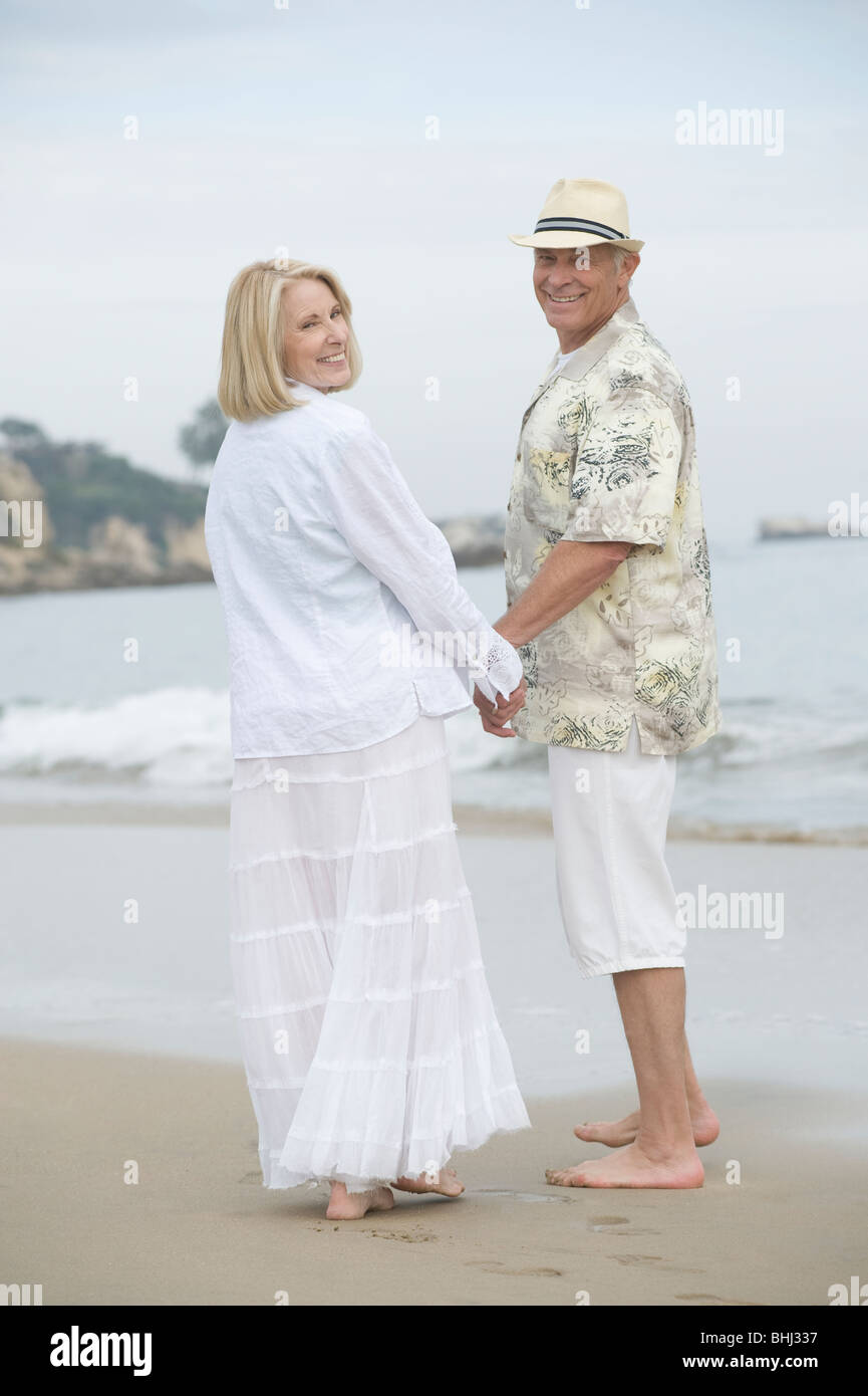 Älteres paar stehen Hand in Hand am Strand Stockfoto