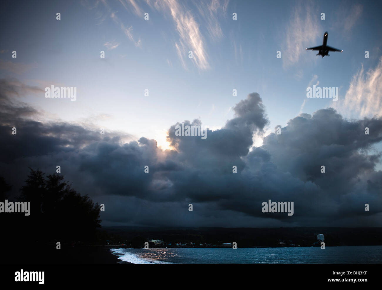 Flugzeug zieht über dunklen Strand Stockfoto