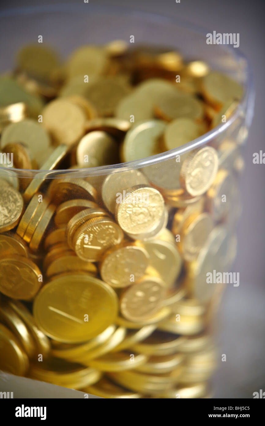 Schokoladen-Münzen in einem Glas Stockfoto