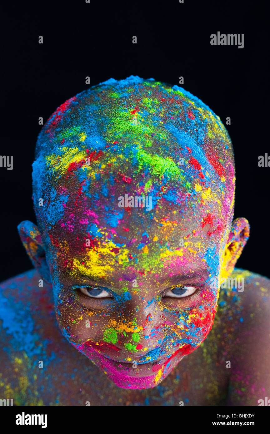 Glücklichen jungen bedeckt Farbpulver Pigment vor schwarzem Hintergrund Stockfoto