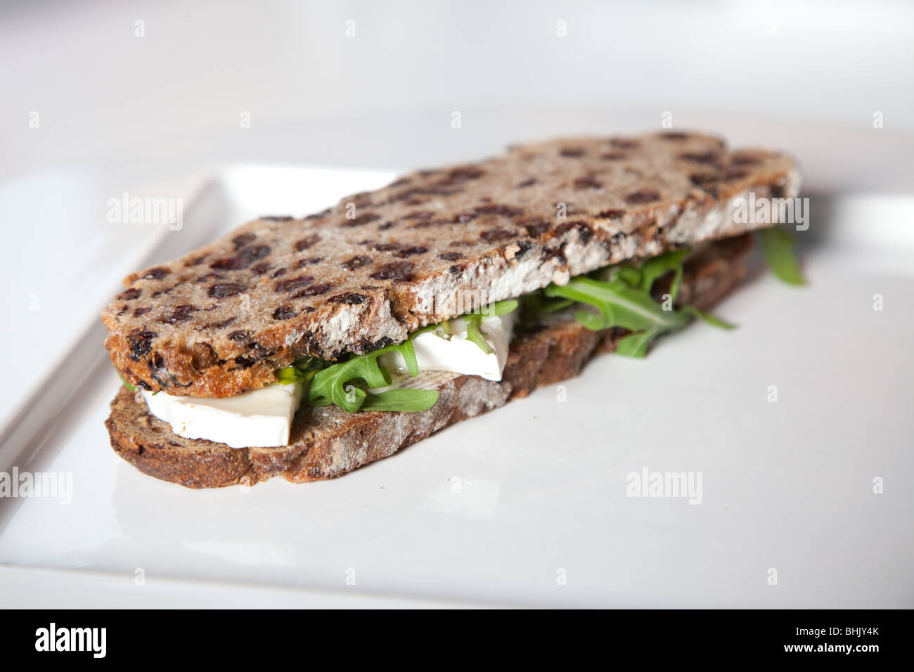 Gesunde Sandwich mit Goatcheese, Honig und Rucola-Salat Stockfoto
