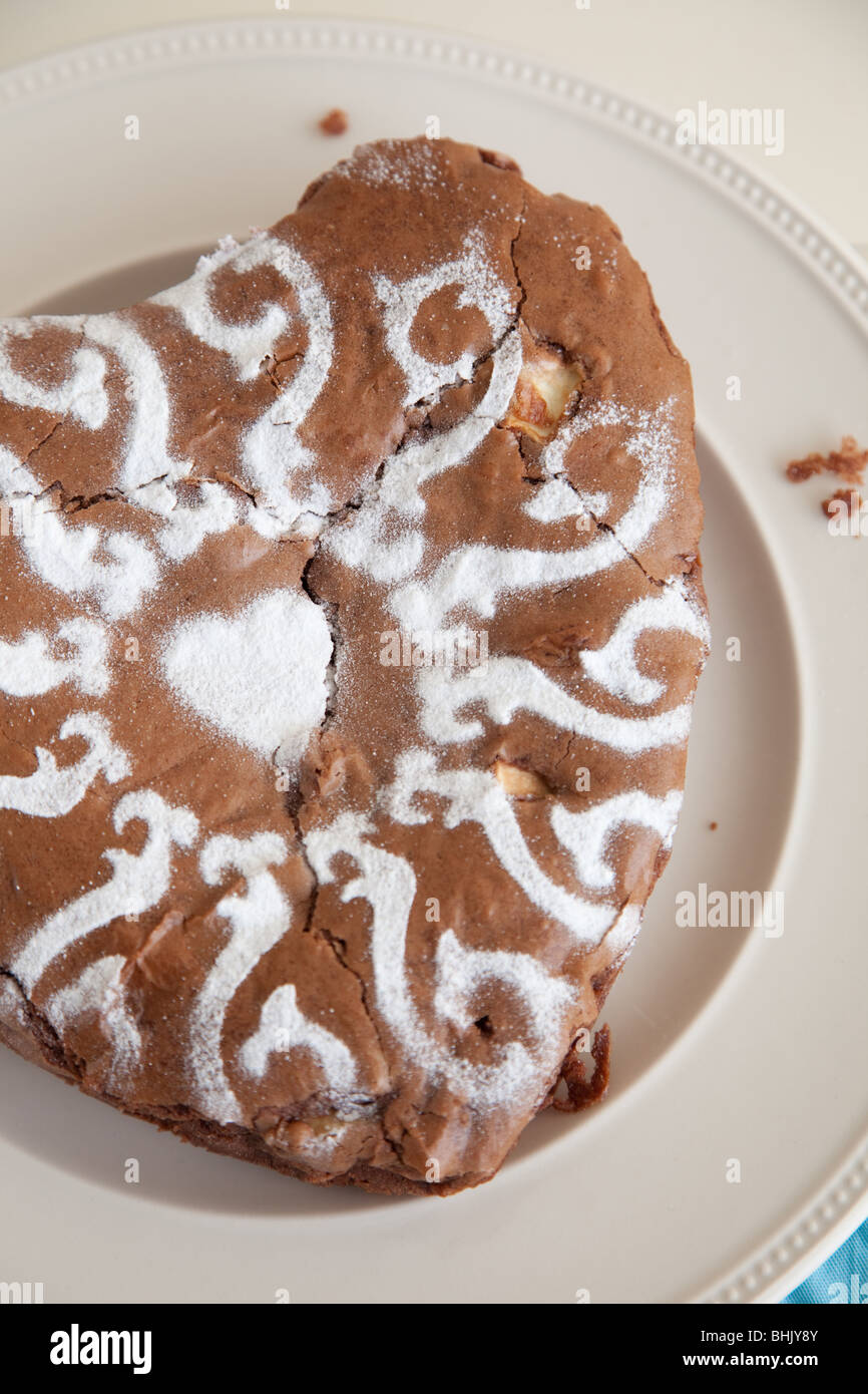 Köstliche Herzform Schokolade Kuchen mit Zuckerguss Zucker Muster an der Spitze Stockfoto