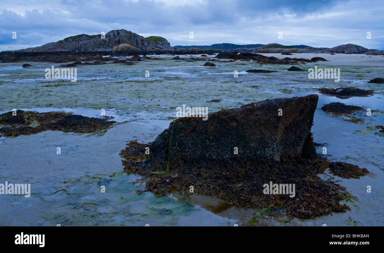 Blick auf den Strand von Fionnphort auf der Westseite der Isle of Mull in Nord-West-Schottland mit Felsen im Vordergrund Stockfoto