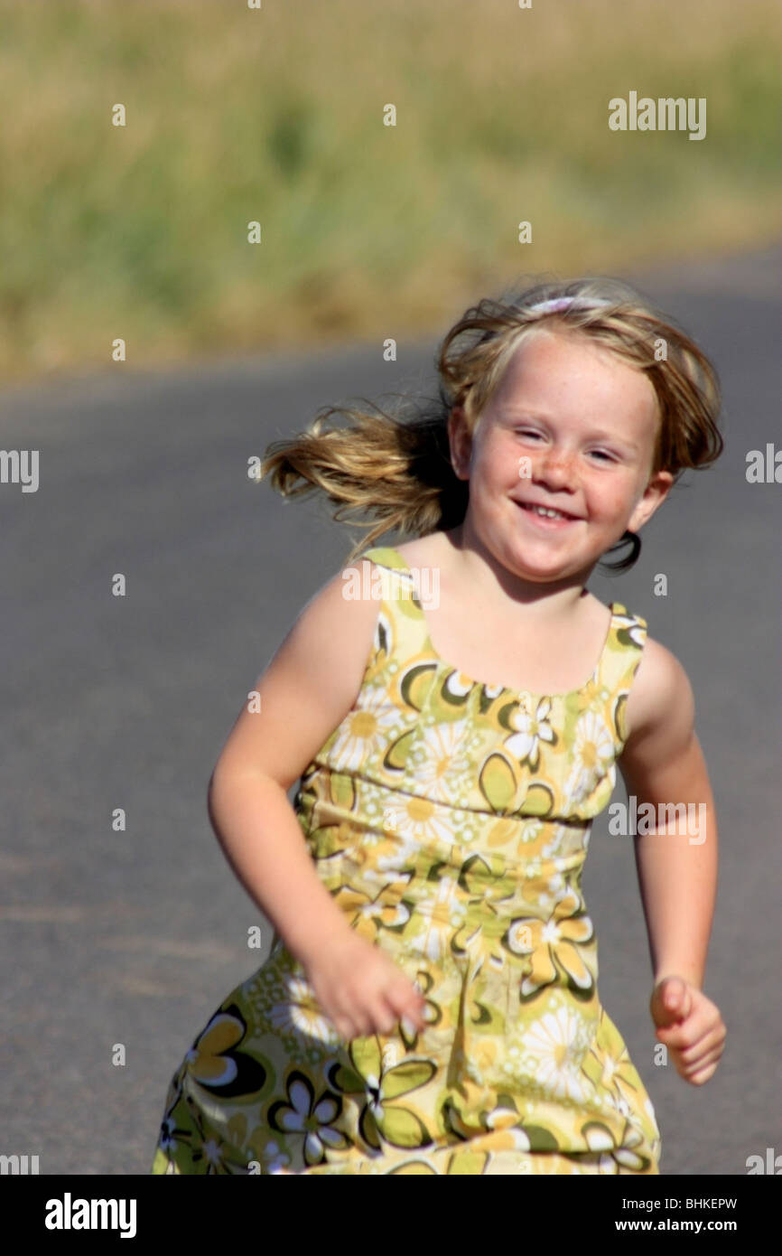 Junge Mädchen laufen gerne im Sommerkleid Stockfoto