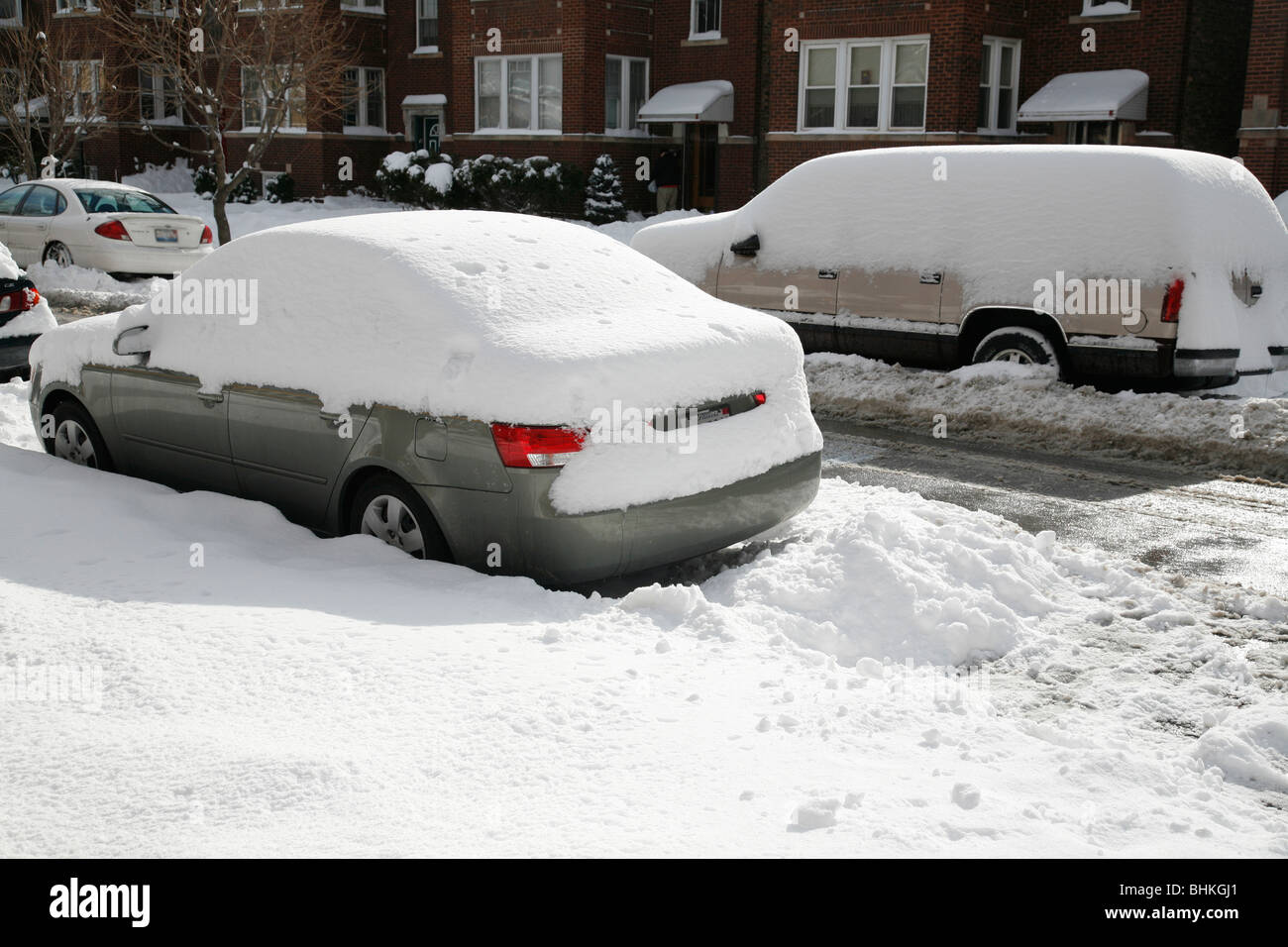 Schnee bedeckt und umgibt ein Auto und LKW geparkt auf einer Straße im winter Stockfoto