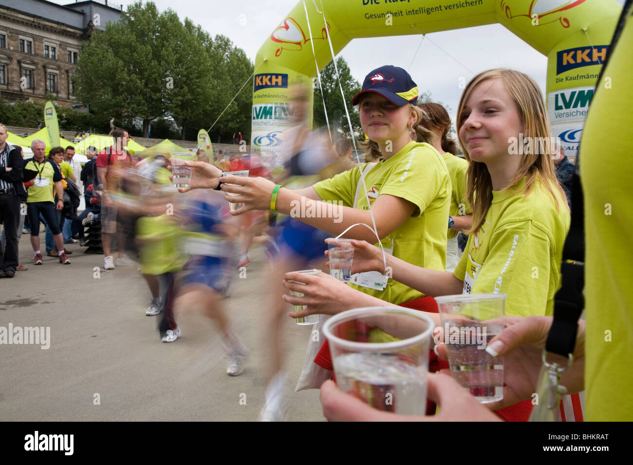 Zwei Mädchen helfen, mit Wasser Gläser für Läufer. Marathon in Dresden, Deutschland Stockfoto