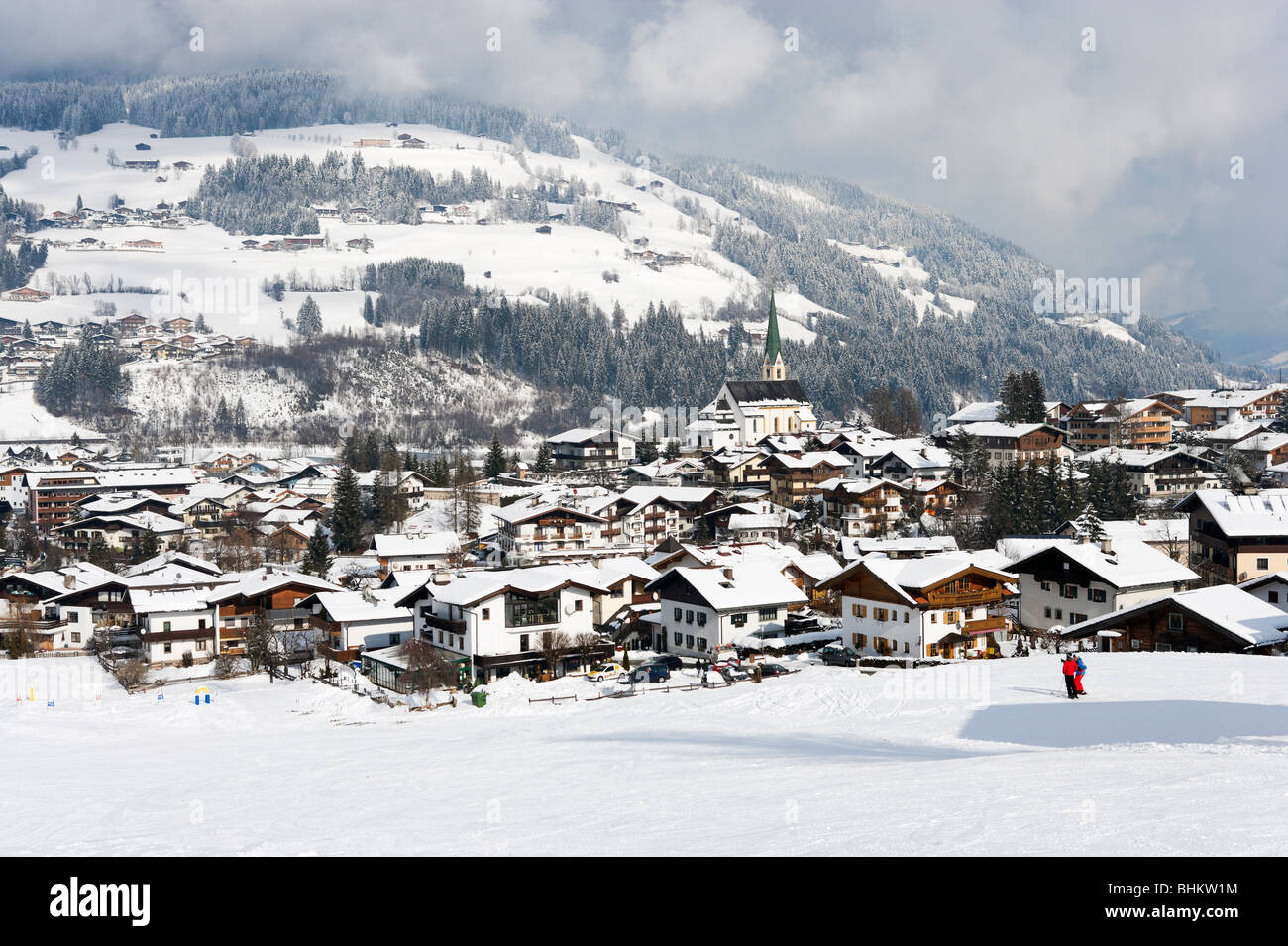 Skifahrer auf der Piste oberhalb des Zentrums von Kirchberg, in der Nähe von Kitzbühel, Tirol, Österreich Stockfoto