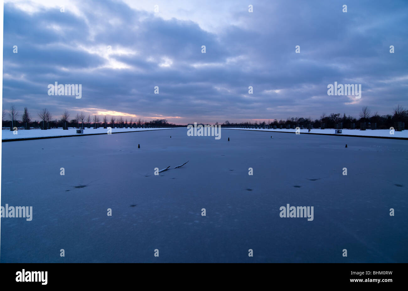 Hampton Court Palace am anderen Ende des langen Wasser mitten im Winter zugefroren Stockfoto