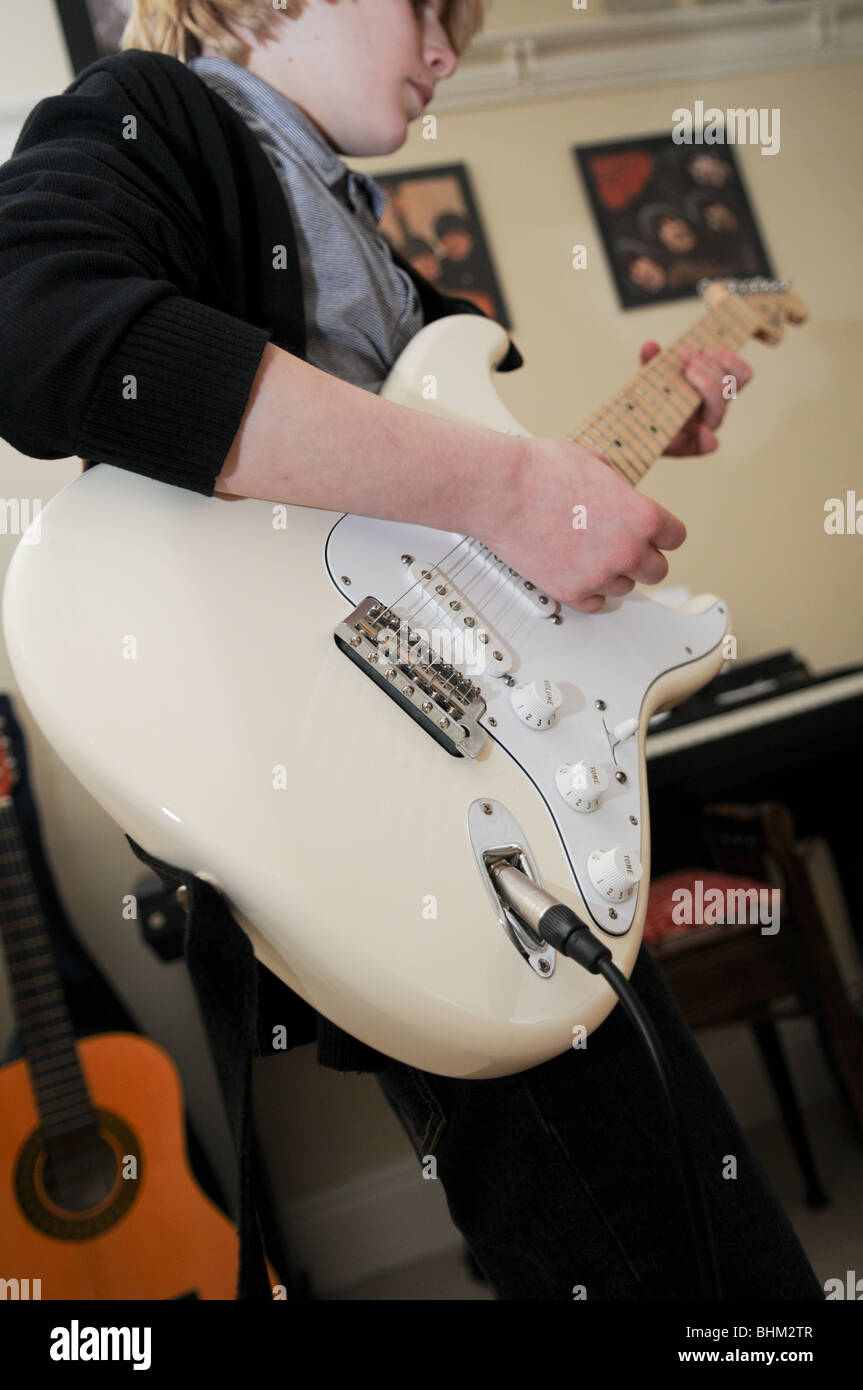 Gitarristen Spielen Eine Creme Fender Stratocaster Mit Klavier Im Hintergrund Und Beatles Alben An Der Wand Stockfotografie Alamy