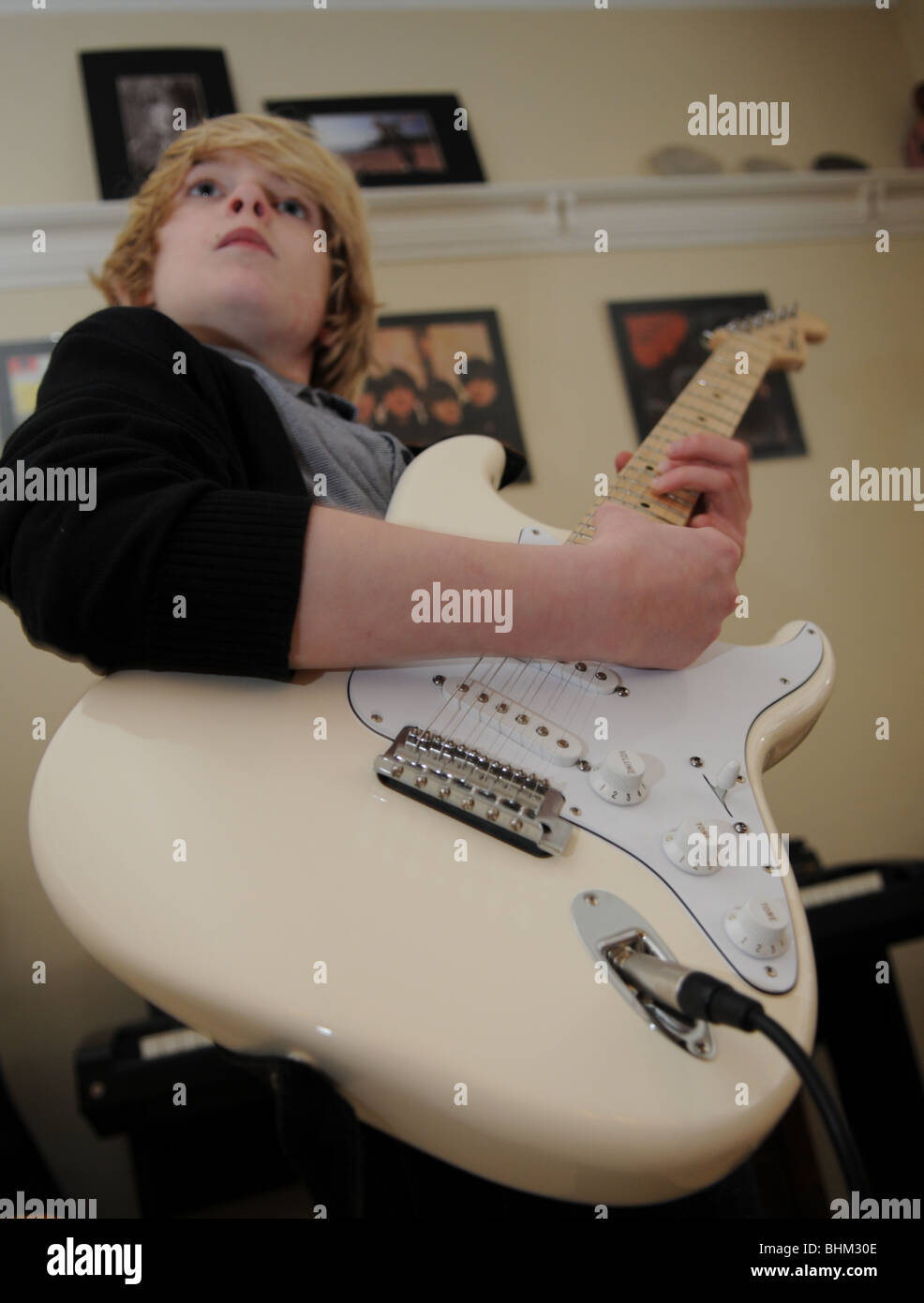 Gitarristen Spielen Eine Creme Fender Stratocaster Mit Klavier Im Hintergrund Und Beatles Alben An Der Wand Stockfotografie Alamy