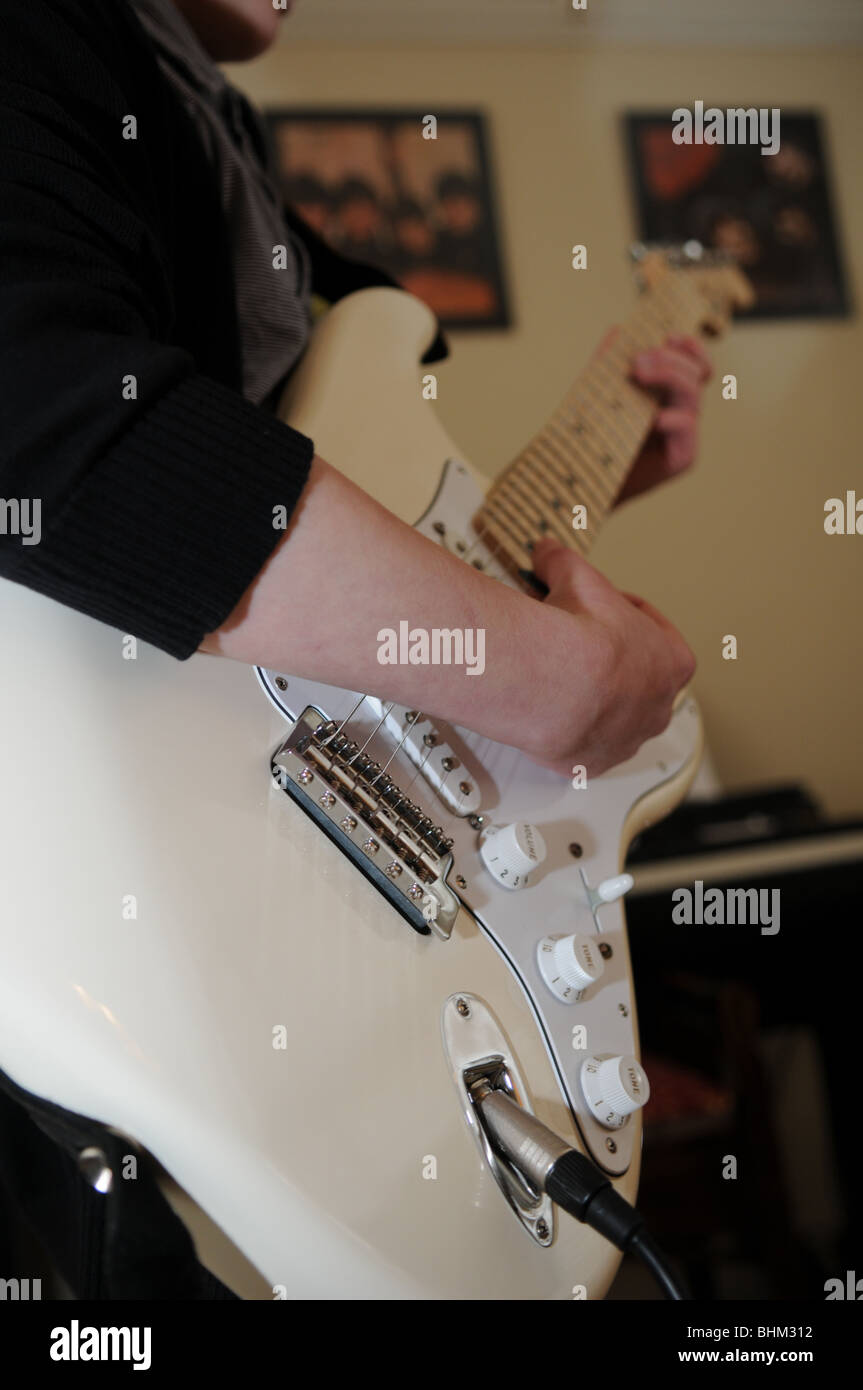 Gitarristen Spielen Eine Creme Fender Stratocaster Mit Klavier Im Hintergrund Und Beatles Alben An Der Wand Stockfotografie Alamy