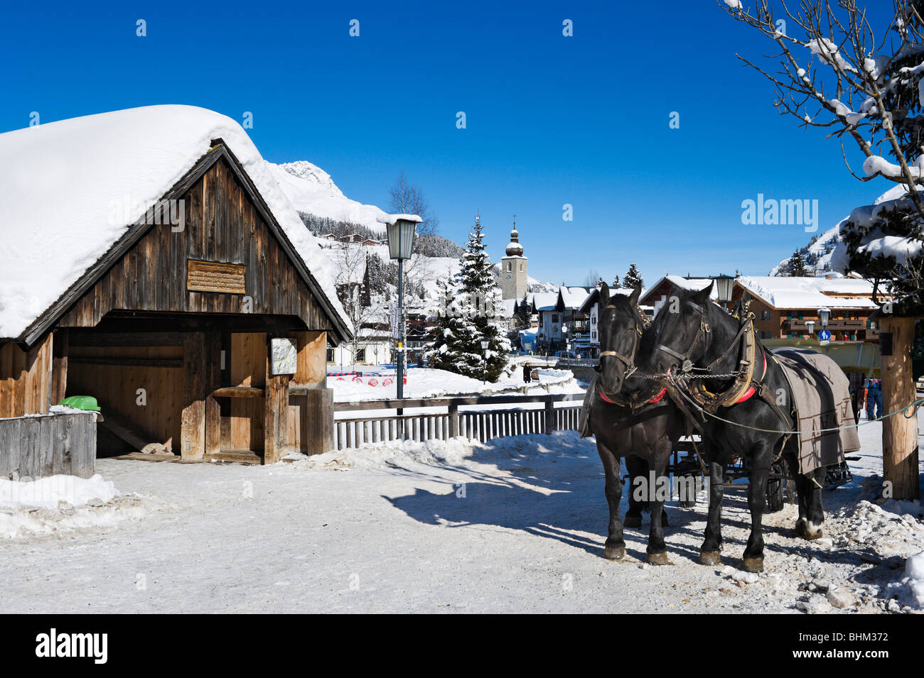 Pferde und Schlitten durch die historische überdachte Tannbergbrucke Brücke, Lech, Skigebiet Arlberg, Vorarlberg, Österreich Stockfoto