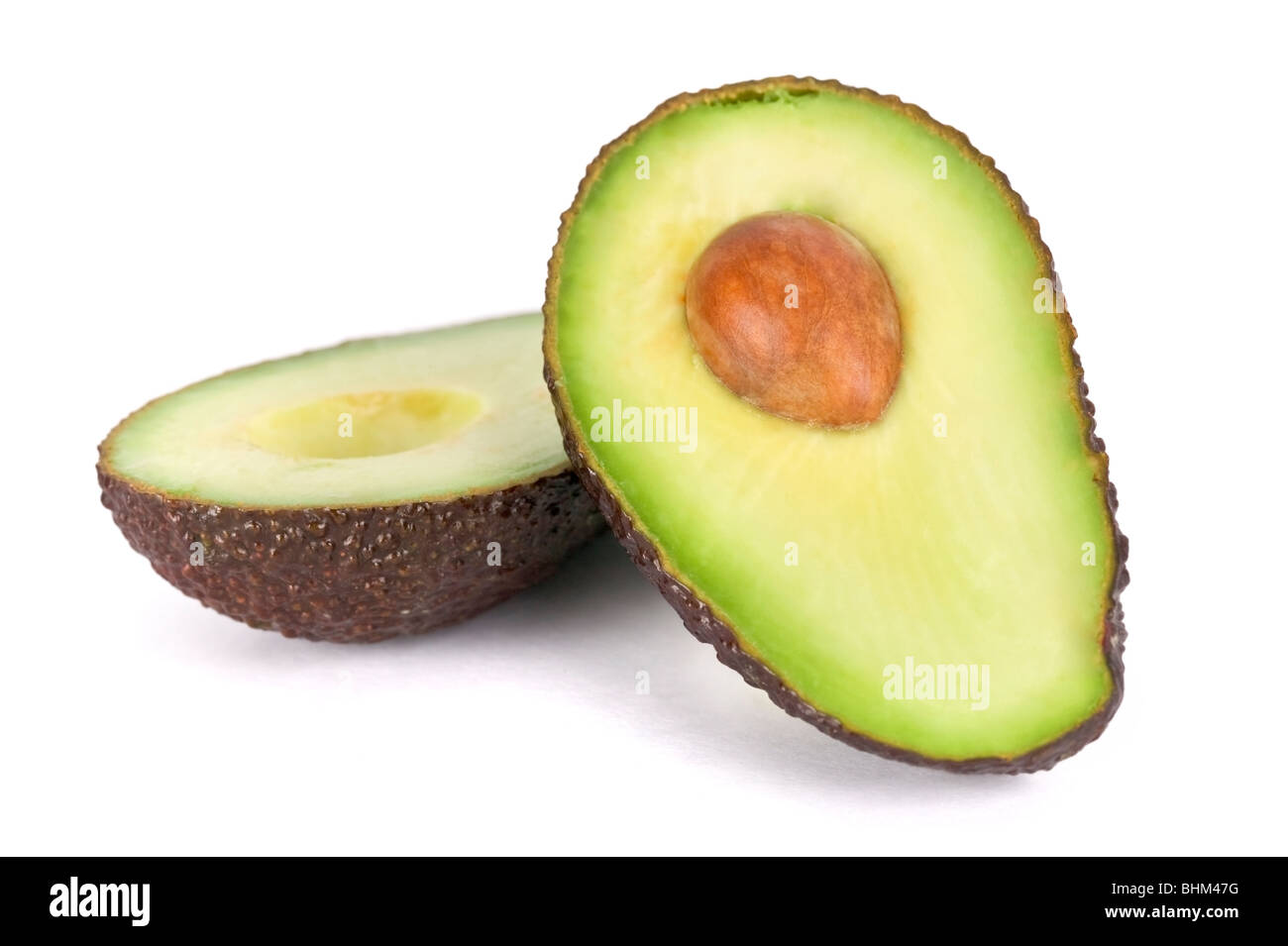 Avocado-Hälften auf weißen Hintergrund, eine Hälfte mit Stein/Kern. Stockfoto