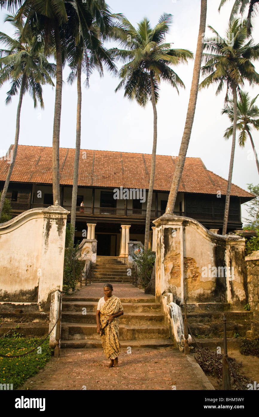 Frau zu Fuß auf den Pfad unter Palmen und Schritte zum Padmanabhapuram Palace, Padmanabhapuram nahe Thuckalay, Tamil Nadu, Indien Stockfoto