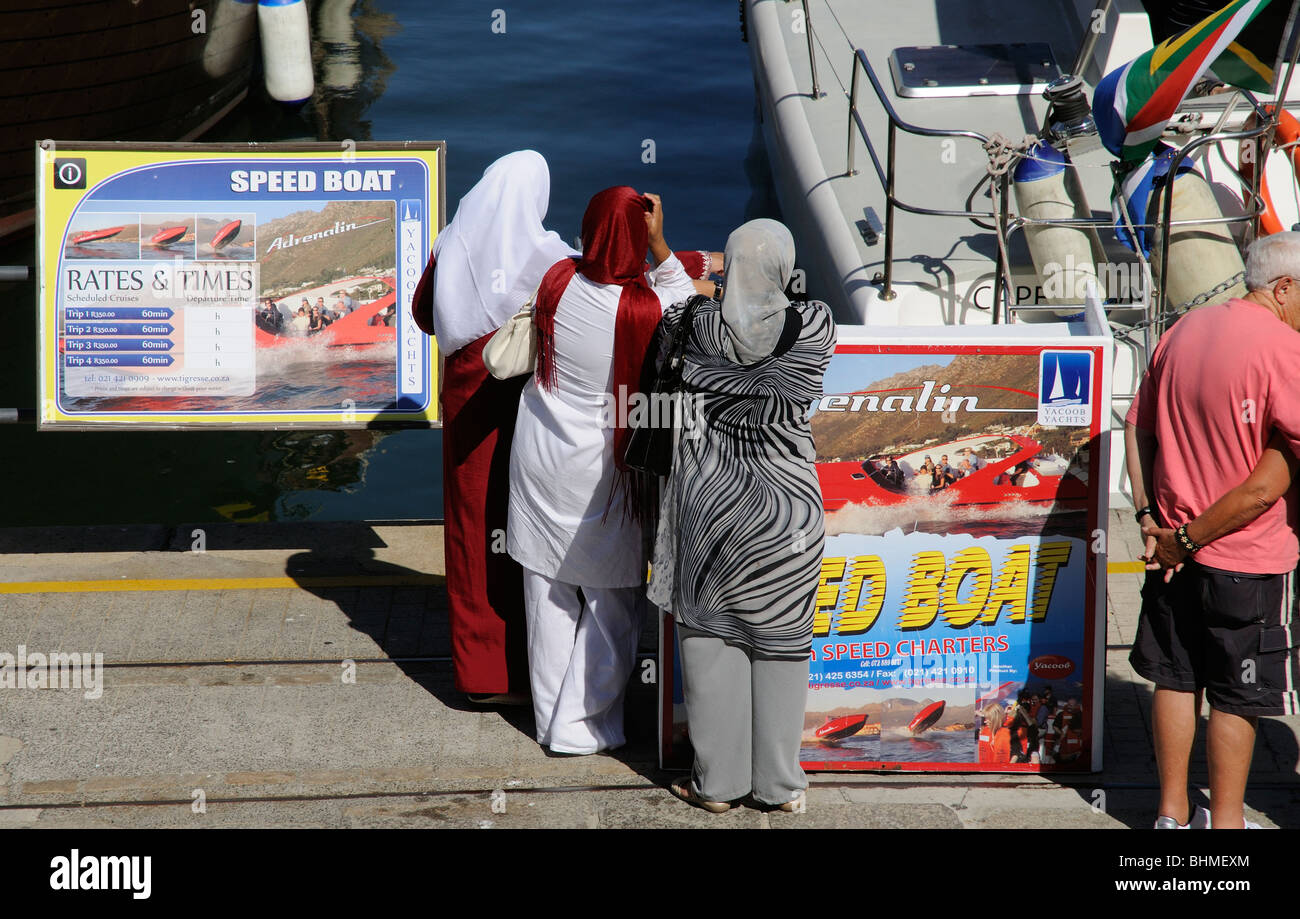 Muslimische Frauen warten, bis eine Geschwindigkeit Bootsfahrt in Cape Town, South Africa Stockfoto