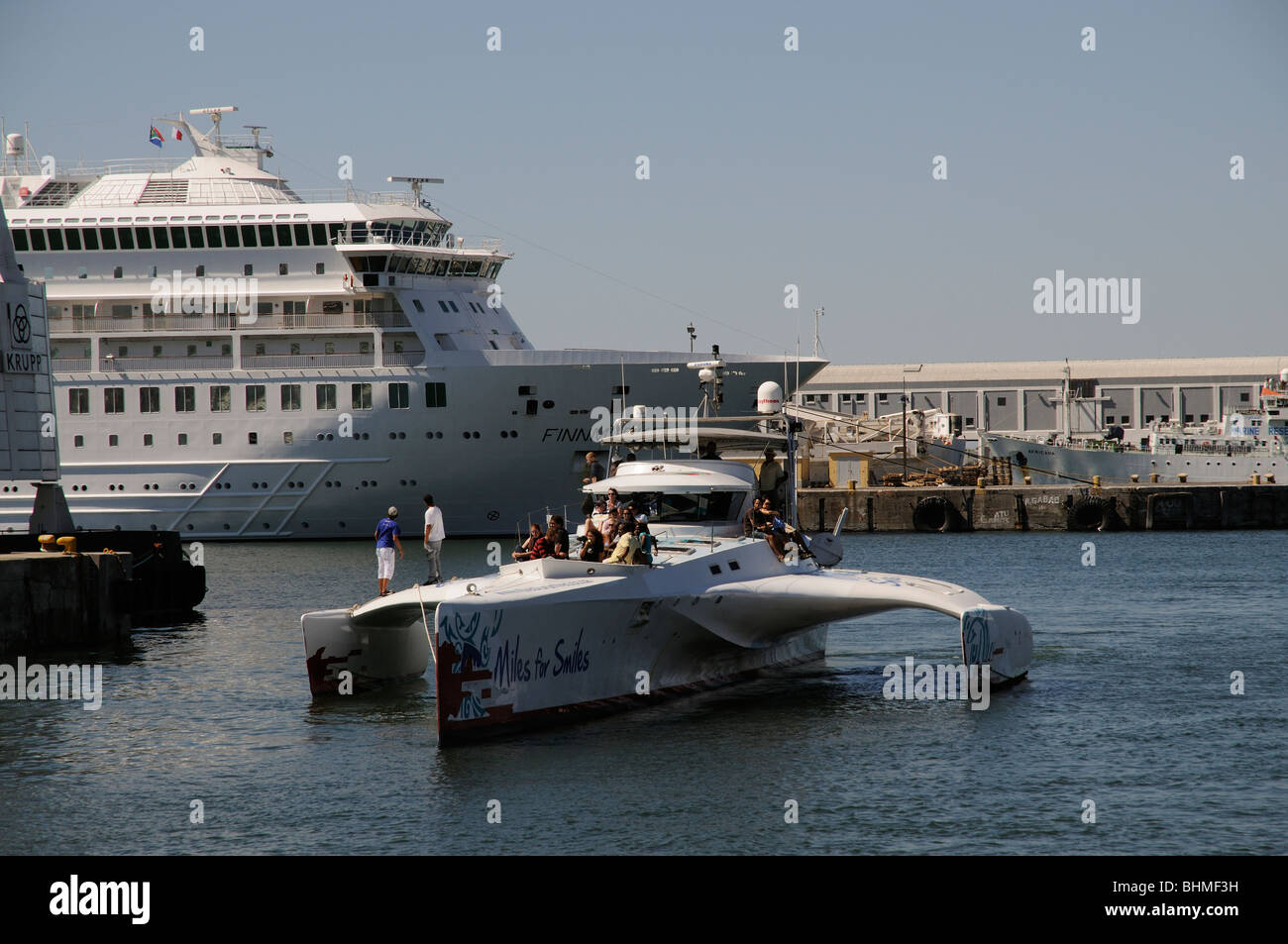 Kapstadt Südafrika-Touristen an Bord ein Ausflugsschiff Meilen zu unterstützen, denn Lächeln vorzubereiten, kommen neben Hafen Stockfoto