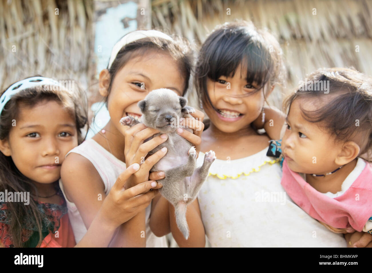 Heimatdorf Kinder halten einen Welpen; Darocotan Insel; Bacuit Archipels; Palawan; Philippinen Stockfoto