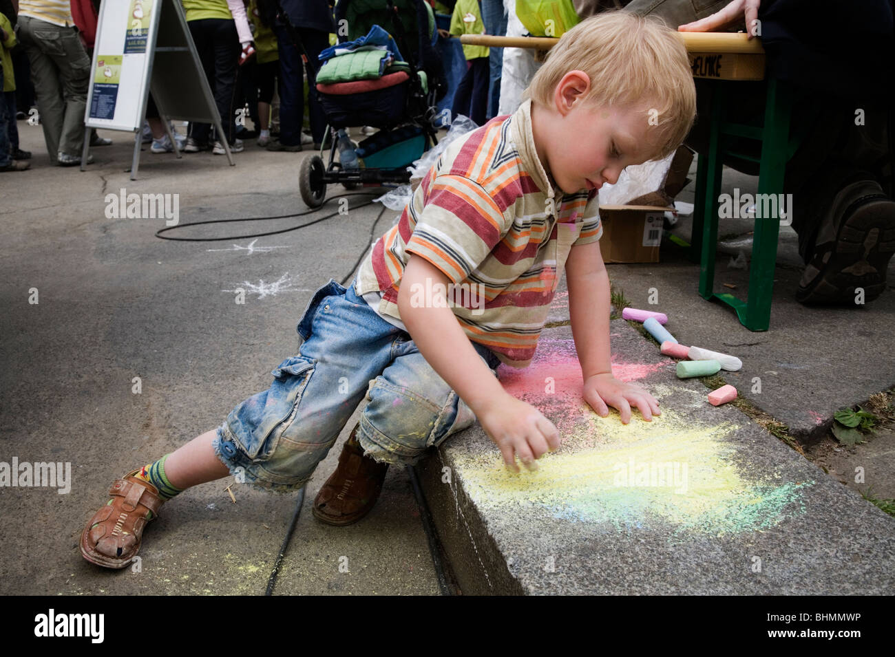 Kleiner Junge zeichnen und malen mit farbiger Kreide im Pflaster, Dresden, Deutschland Stockfoto