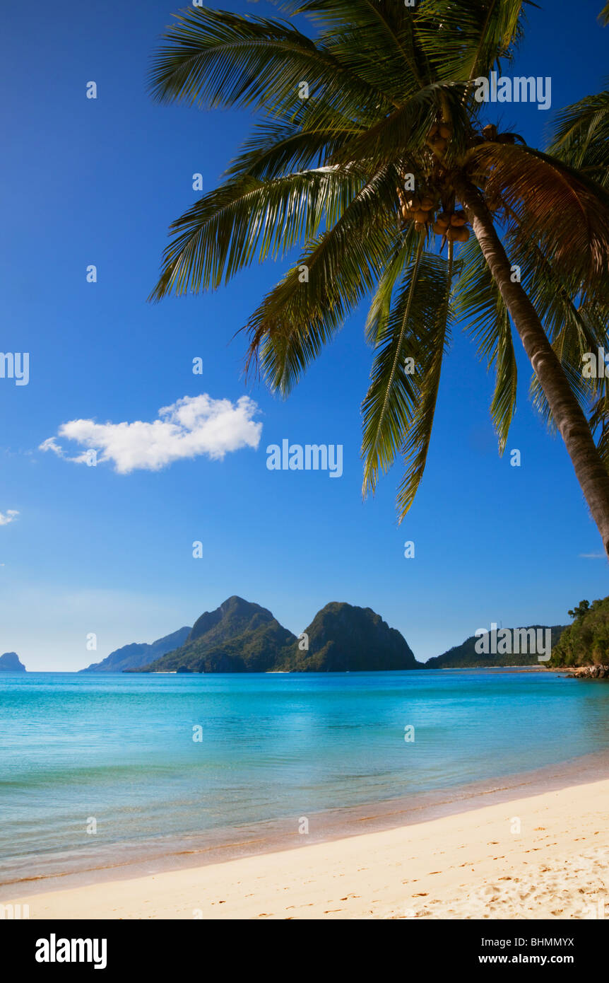 Blick durch Palmen, Strand, Meer und Inseln; Las Reetdächern; El Nido; Bacuit Archipels; Palawan; Philippinen. Stockfoto