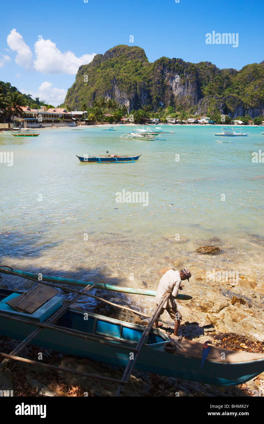 Befestigung der Banca Boot Mann; El Nido; Bacuit Bay; Palawan; Philippinen. Stockfoto